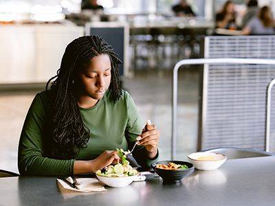 Student eats meal on campus indoors