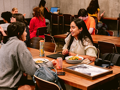 Two students chat over a meal indoors