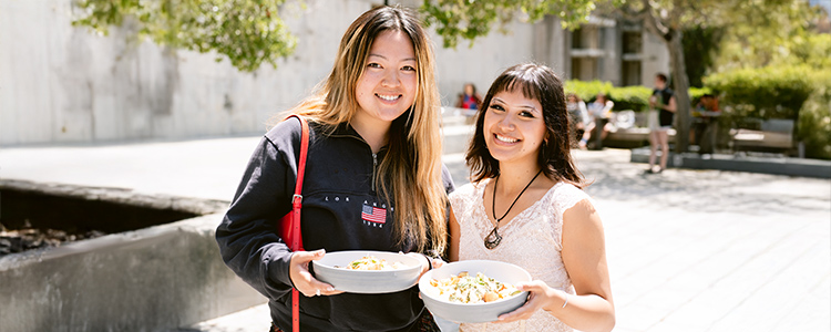Students carry their to-go meal outside