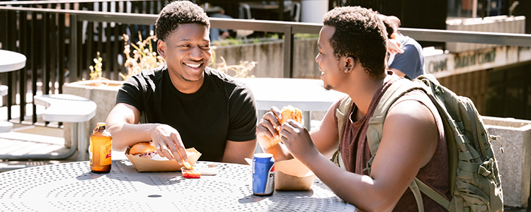 Two students eating their meals outside